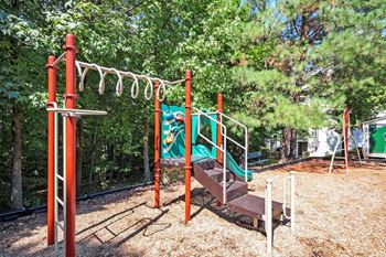 A swing set with a slide and monkey bars in a park